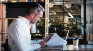 businessman accountant and documents with laptop for AI Tools in Your Business Contracts: What Every Atlanta Company Needs to Address Before Problems Arise