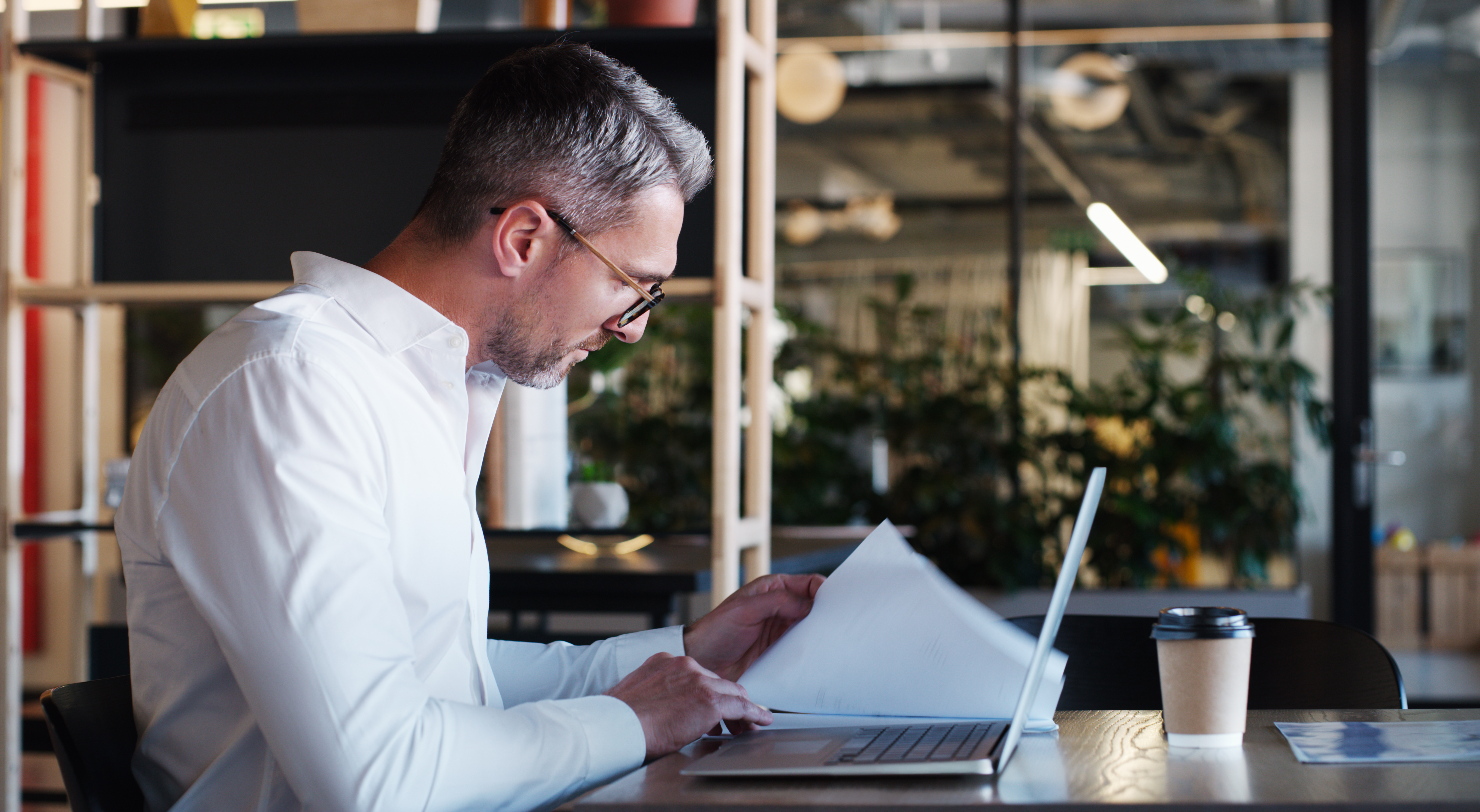 businessman accountant and documents with laptop for AI Tools in Your Business Contracts: What Every Atlanta Company Needs to Address Before Problems Arise