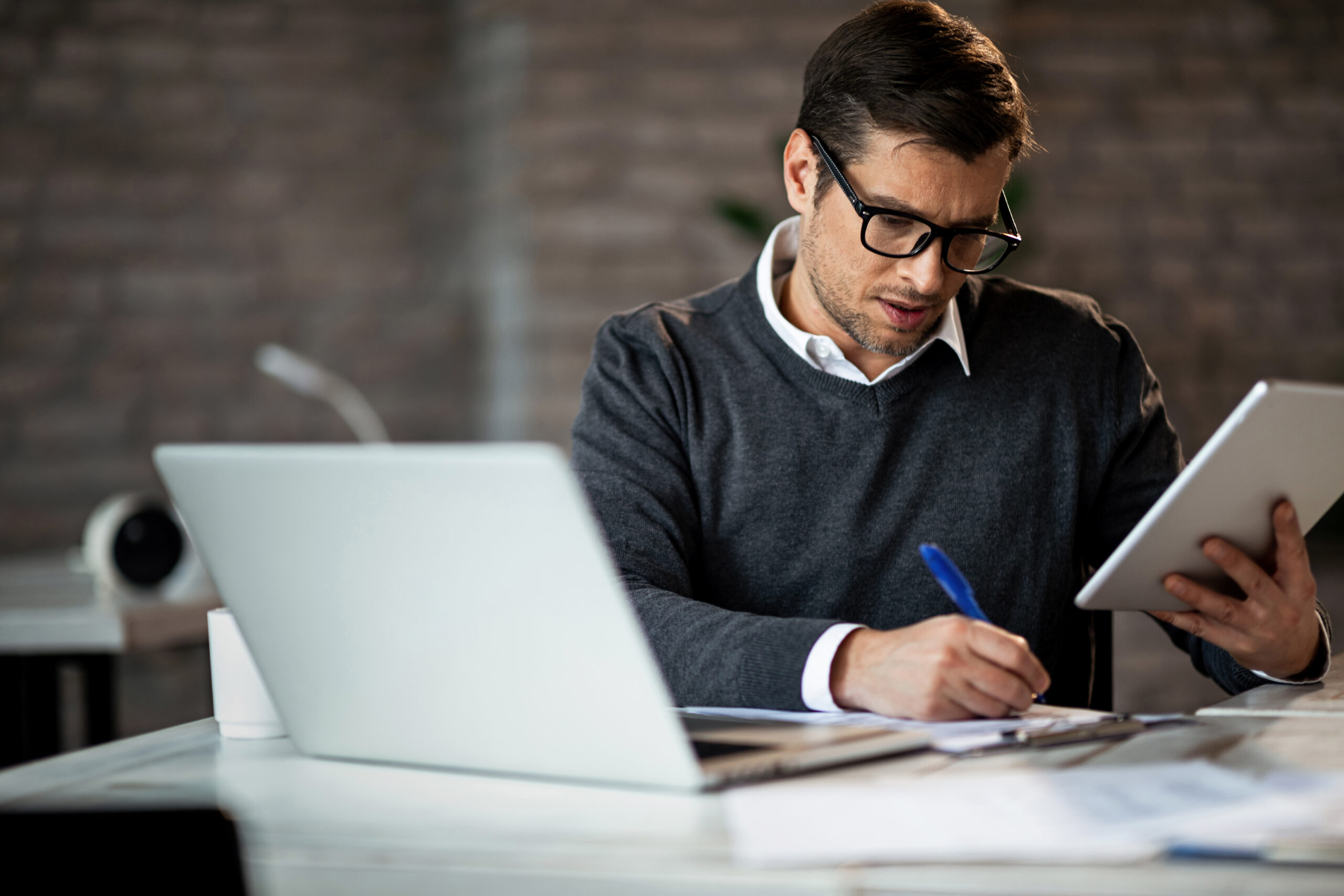 dedicated entrepreneur taking notes while using di for What to Expect From M&A Due Diligence: A Small Business Guide for Buyers and Sellers in Atlanta